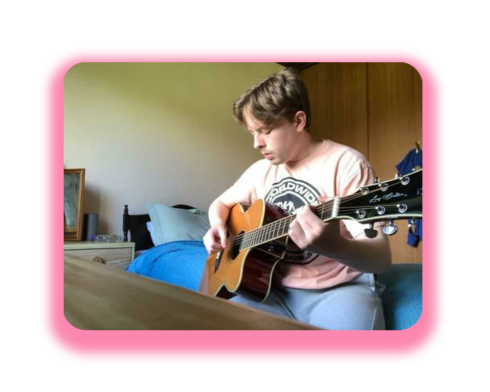 Olly playing his guitar at home